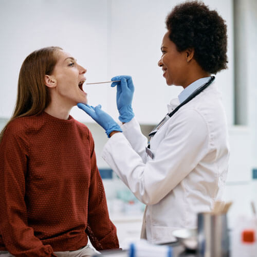 usaDra ndo depressor de língua enquanto verifica a garganta da paciente para fazer exames de análises clínicas na Global exames Dra usando depressor de língua enquanto verifica a garganta da paciente para fazer exames de análises clínicas na Global exames