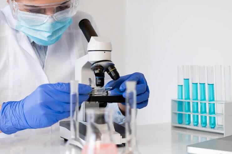 Médica examinando amostra para o exame de espermograna na Global exames