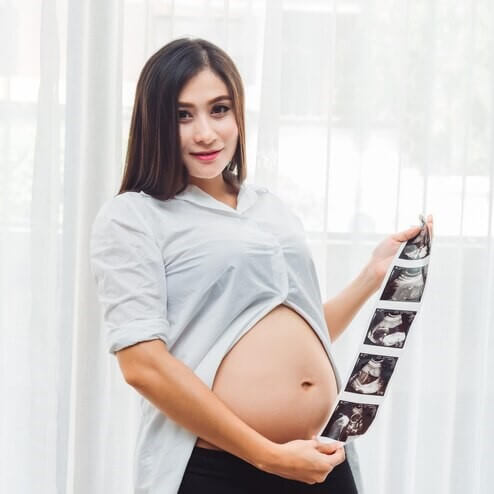 Mulher mostrando as imagens do seu ultrassom morfológico feito na Global exames Mulher mostrando as imagens do seu ultrassom morfológico feito na Global exames
